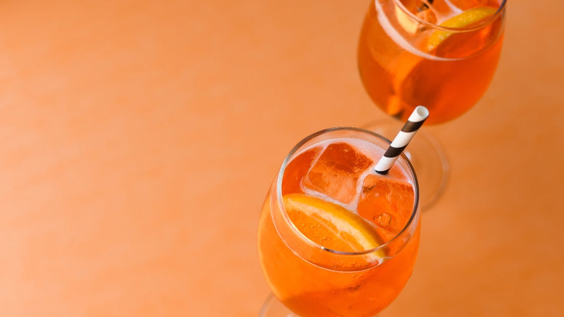 Coco Loco Passionfruit Aperol Spritz in wine glass on orange background