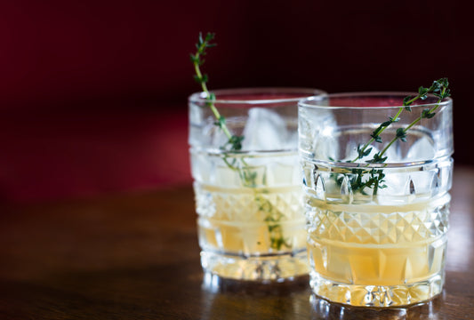 Crystal glasses with coconut water alcohol and fresh rosemary