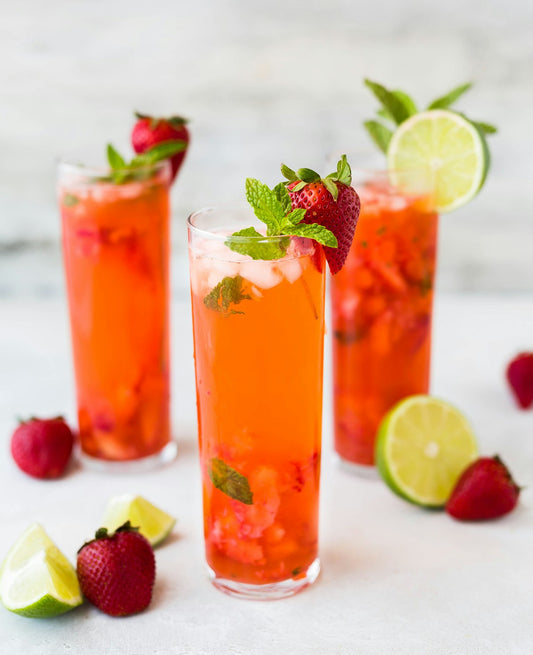 Frozen Tropical Slushie in tall glasses with fresh fruit garnish. Photo by Whitney Wright on Unsplash