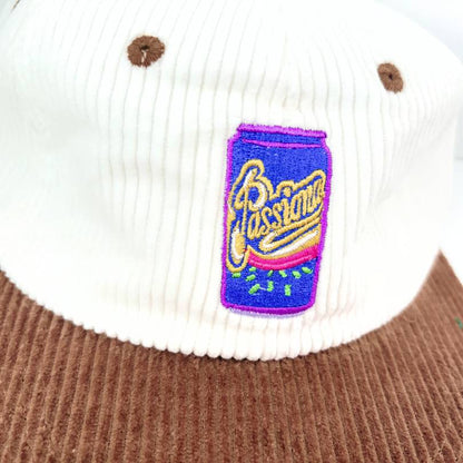 Close-up of the embroidered Passiona can badge, purple and blue with gold script, stitched on white corduroy