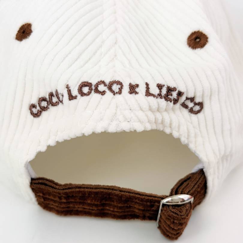 Back of the Passiona cap showing COCO LOCO x LIES CO embroidered in brown above the adjustable metal clip