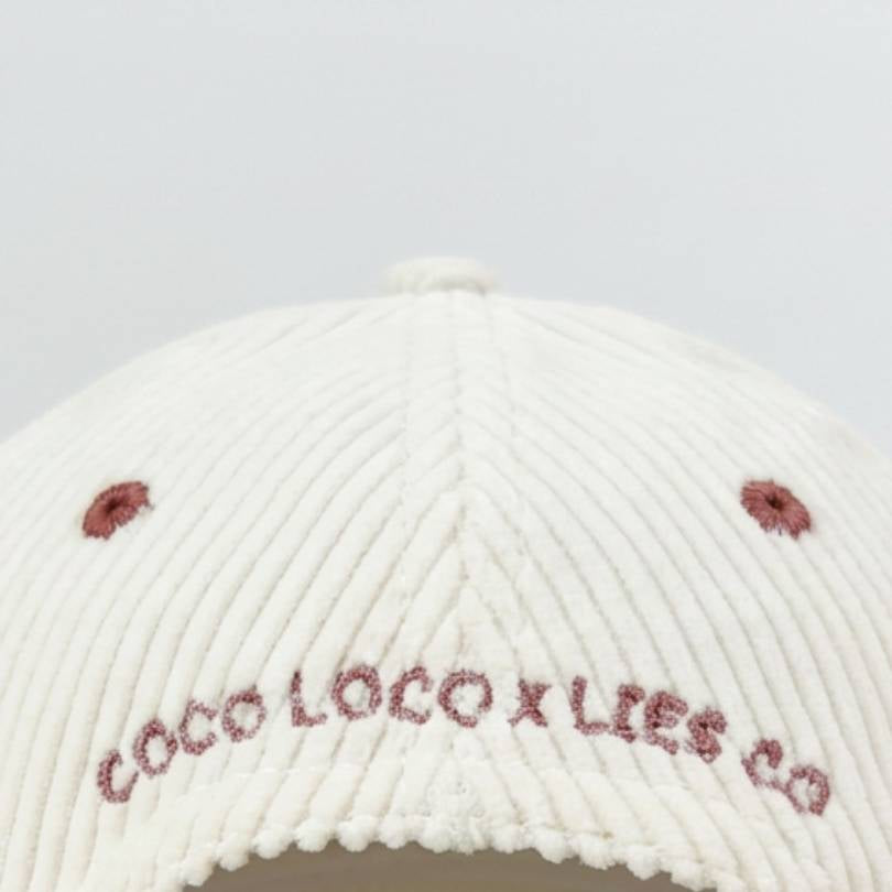 Back of the Pina Colada cap with COCO LOCO x LIES CO embroidered across white corduroy