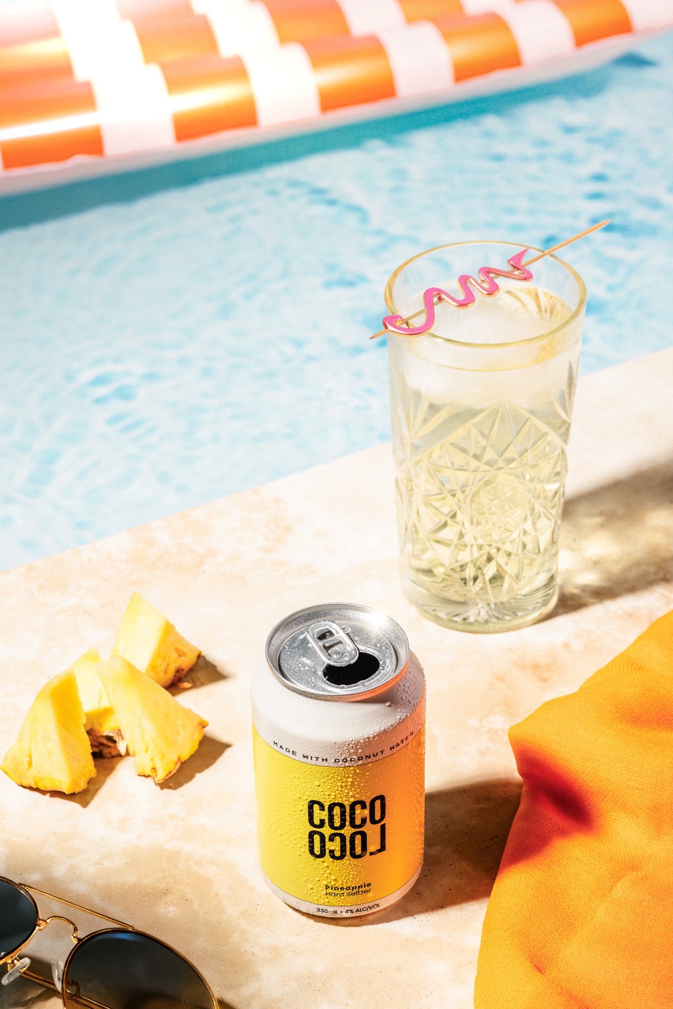 Brewed coconut water hard seltzer poured into crystal glass beside a Coco Loco pineapple seltzer can
