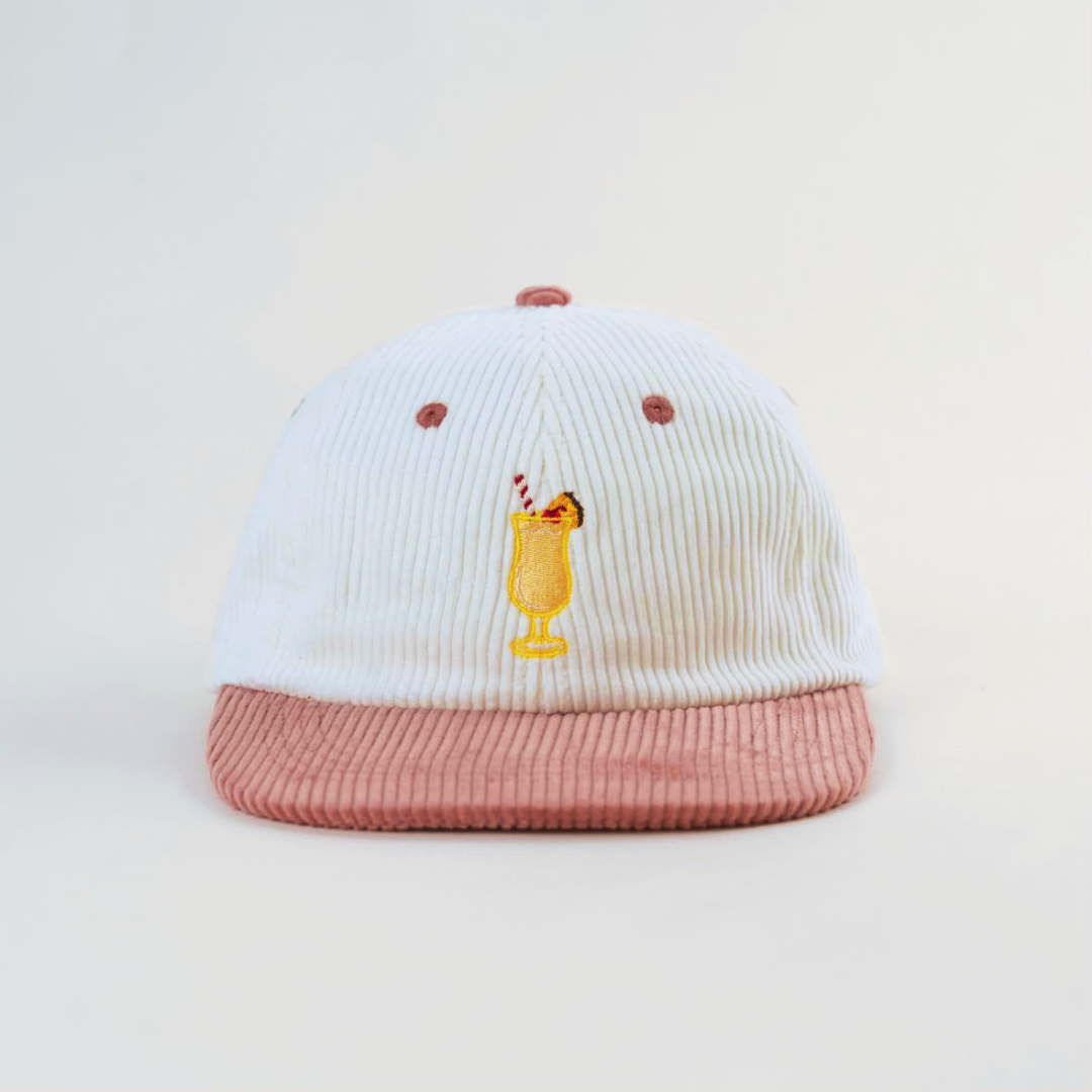 Coco Loco × Lies Collective Piña Colada cap — white corduroy dad cap with pink brim, front view