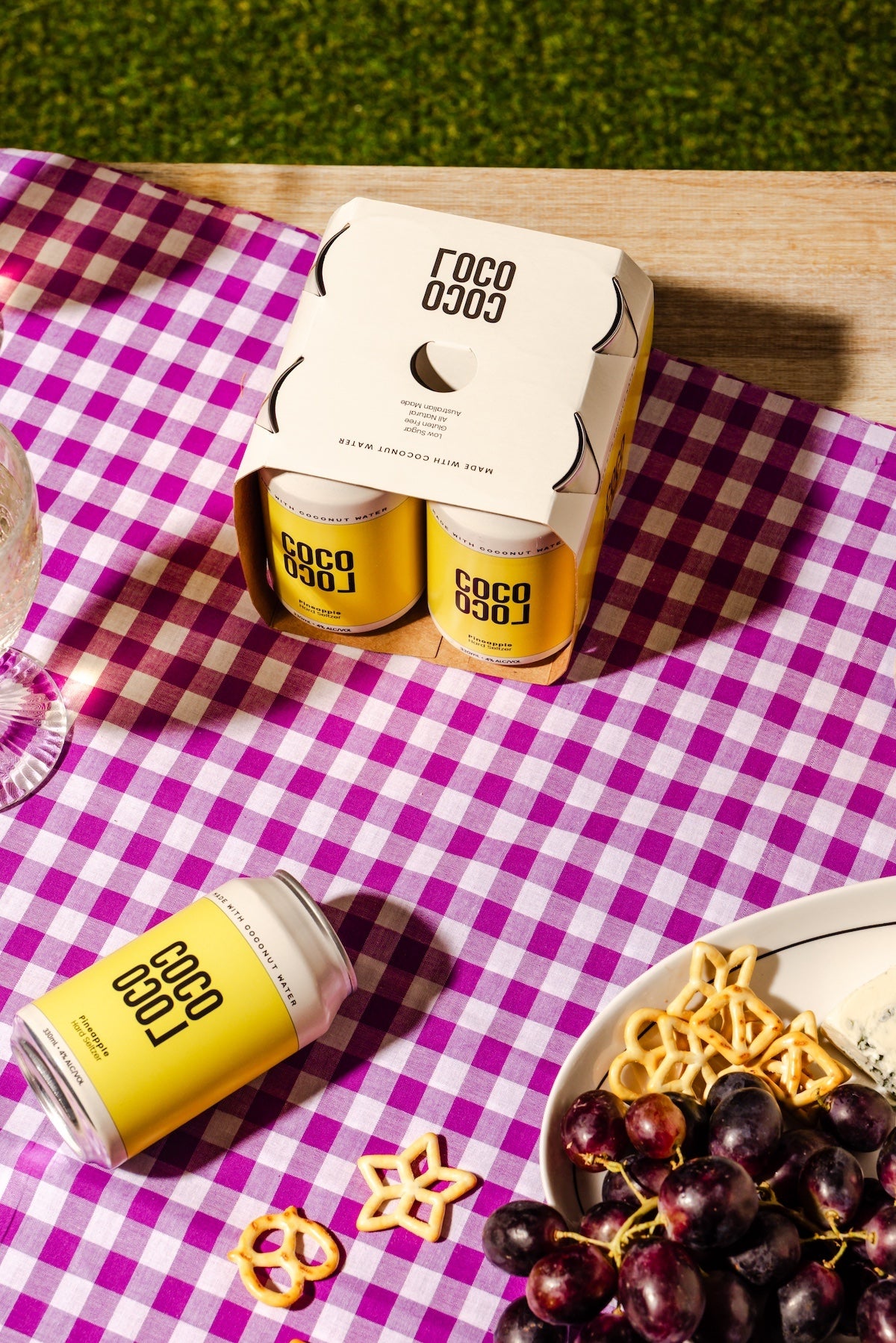 COCO LOCO cans on a purple checkered tablecloth with snacks